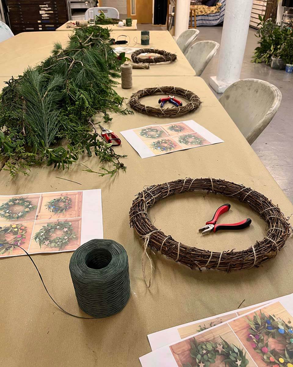 Tables set up for a festive wreath making evening at West Hove Studio