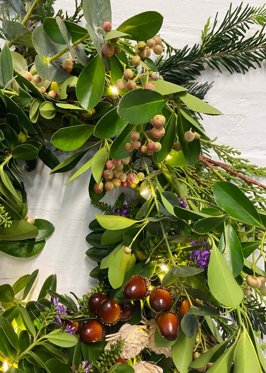 Close-up of a handmade Christmas wreath with festive accessories